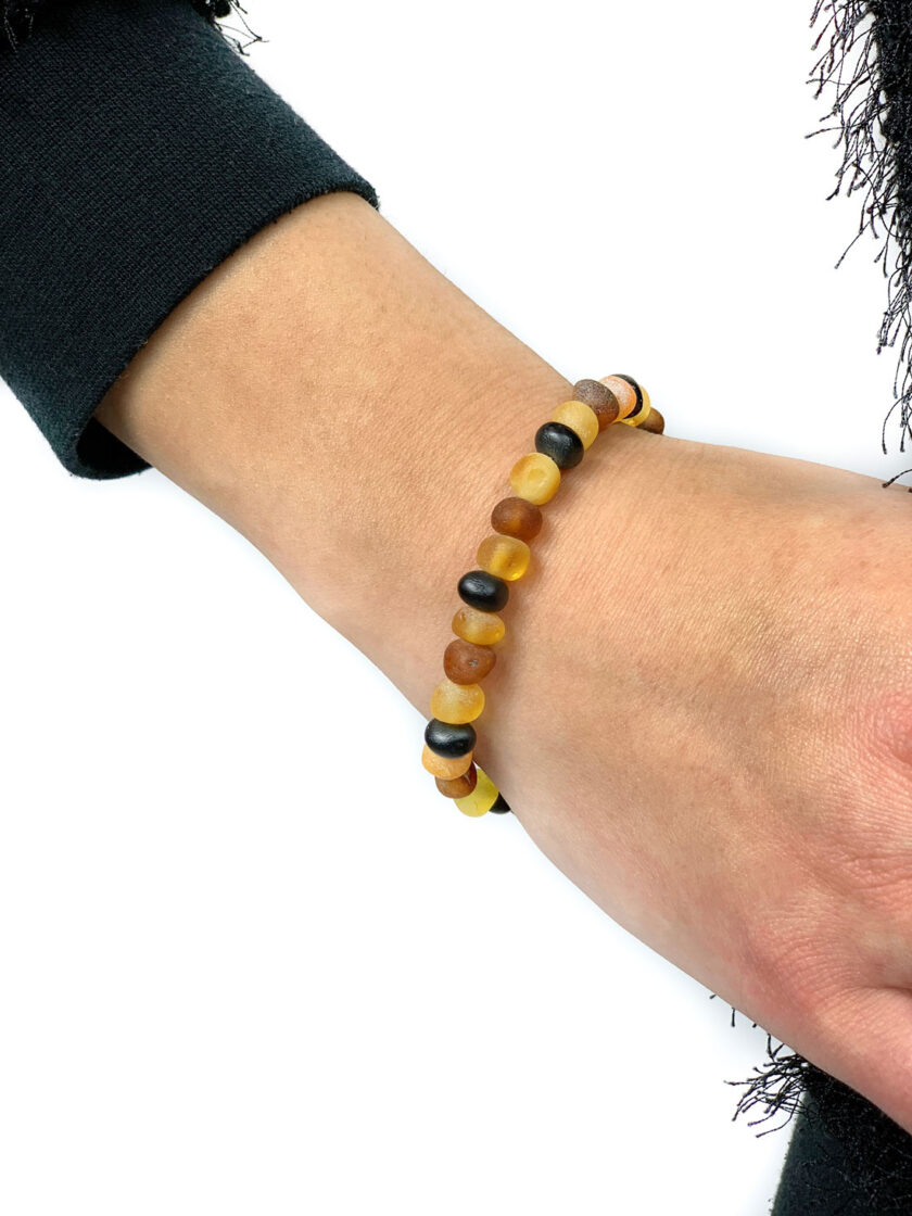 unpolished multi color amber bracelet on hand