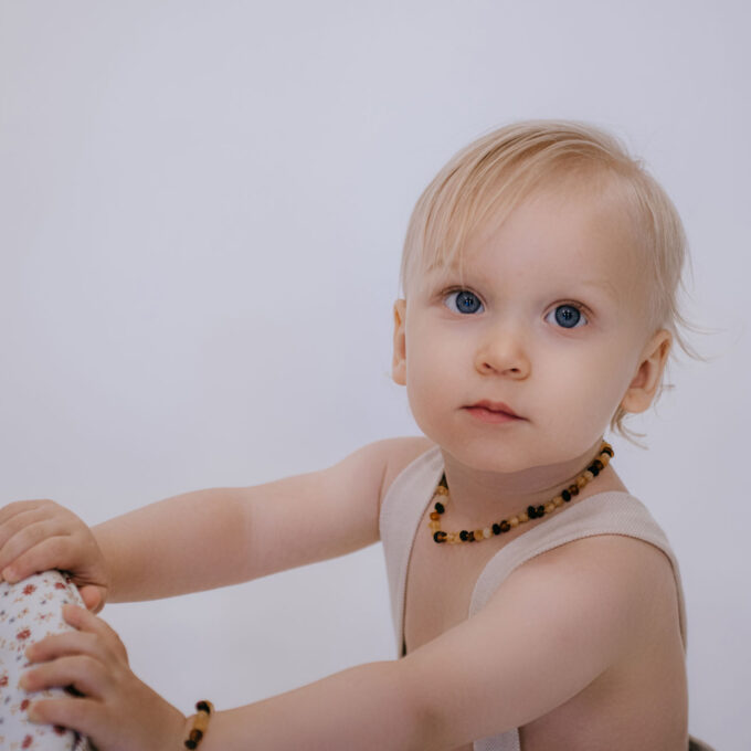 baby wearing raw mixed color amber necklace