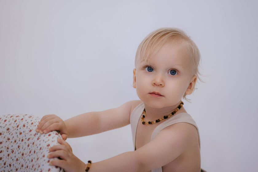 baby wearing raw mixed color amber necklace