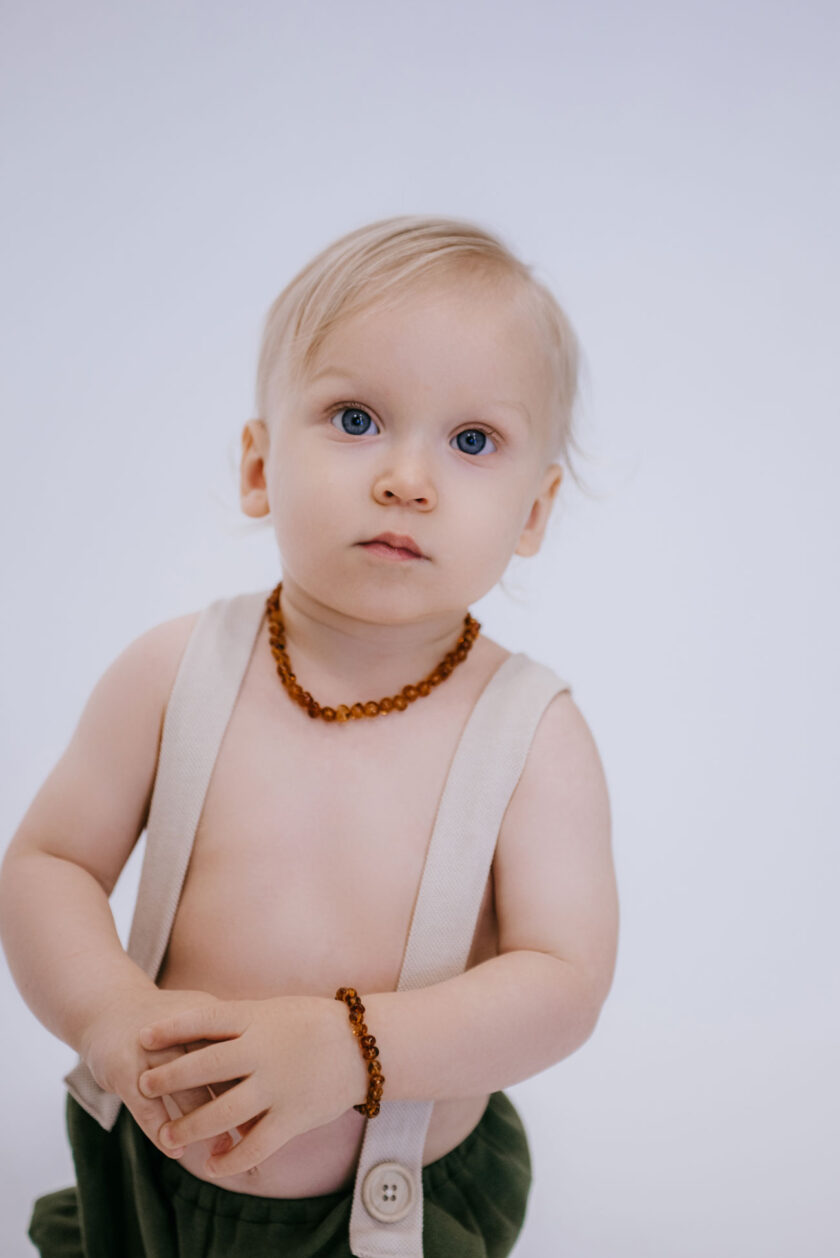 baby wearing cognac color amber teething necklace