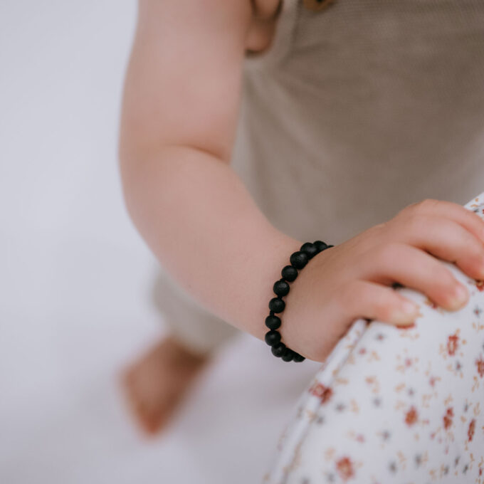 pulsera para dentición de ámbar negro crudo en el brazo del bebé