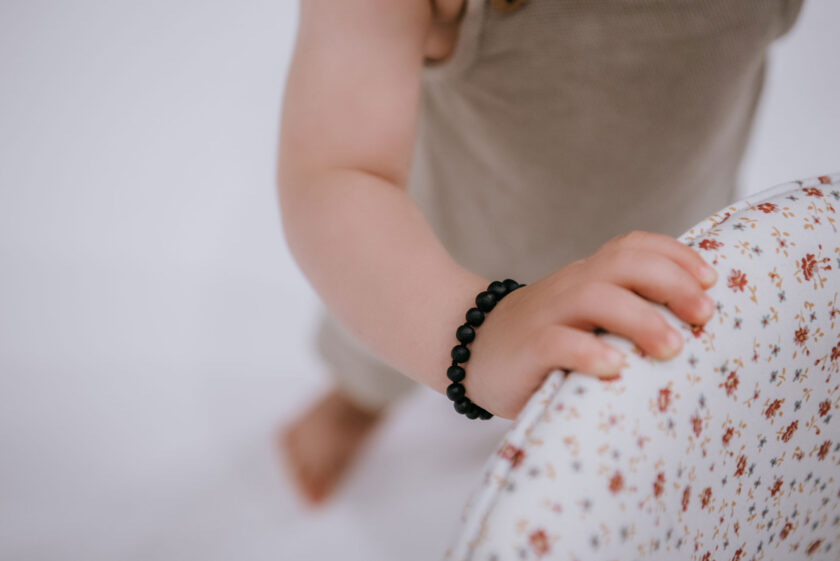 raw black amber teething bracelet on baby arm