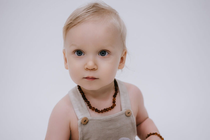 baby with raw cognac color amber teething necklace and bracelet