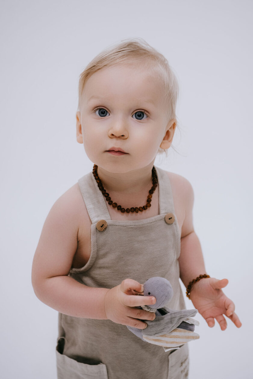 baby wearing raw amber bracelet and necklace
