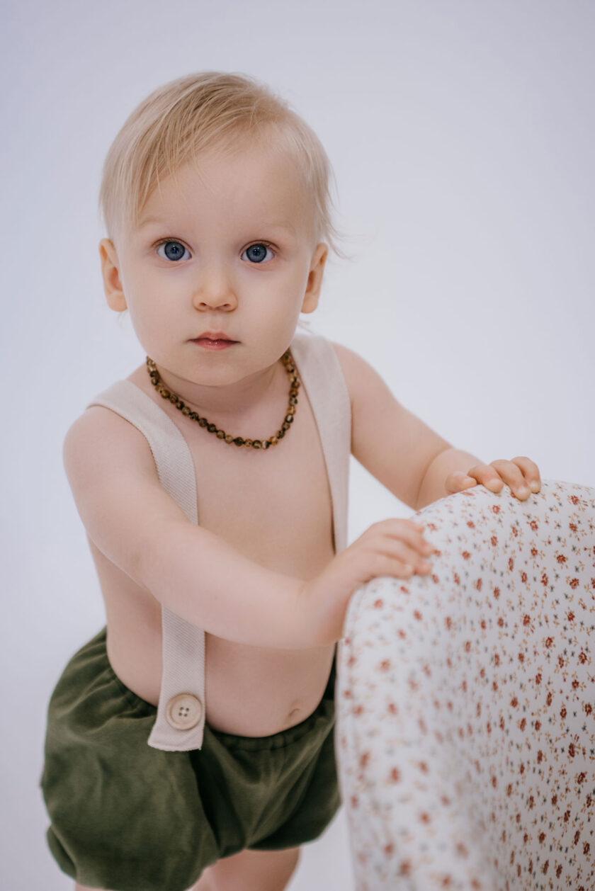 baby wearing green amber teething necklace