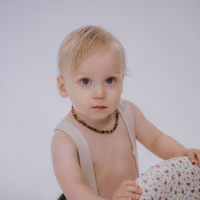 green amber necklace on baby